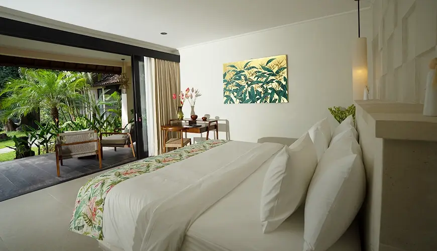 Le Sunset, Ubud, Bali — cozy cottage villa bedroom featuring a clean bed and sliding glass doors leading to a private | The Luxury Bali