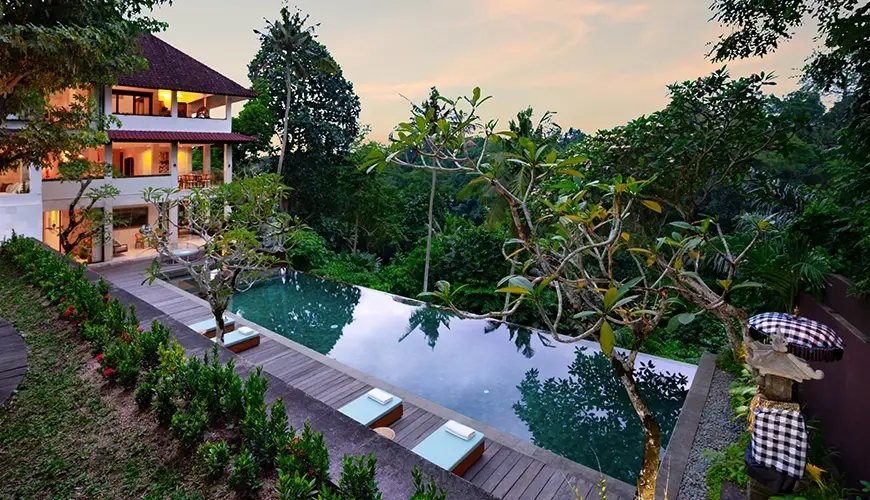 Le Sunset, Ubud, Bali — modern villa pool area with a wooden deck and scenic cliff views during golden hour | The Luxury Bali