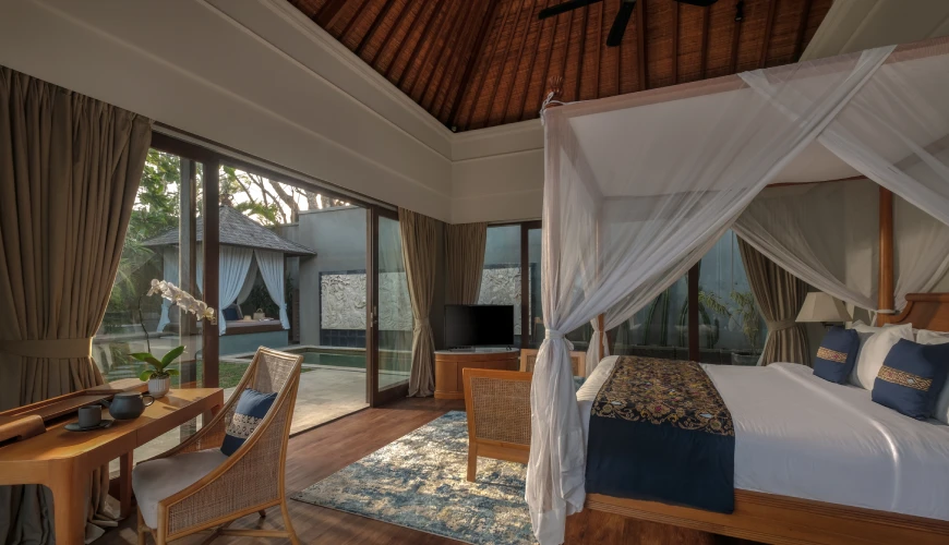 Shanti Residence, Nusa Dua, Bali — elegant villa bedroom with a canopy bed and glass doors opening to a private pool area | The Luxury Bali