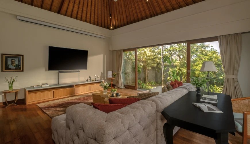 Shanti Residence, Nusa Dua, Bali — modern villa entertainment room featuring a television and comfortable tufted sofa with a lush garden view | The Luxury Bali