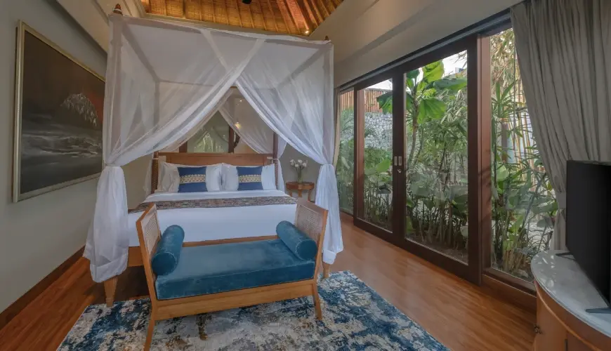Shanti Residence, Nusa Dua, Bali — spacious villa bedroom with a king sized bed and sliding glass doors revealing a lush garden | The Luxury Bali