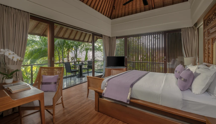 Shanti Residence, Nusa Dua, Bali — tropical villa bedroom featuring purple accents and a private balcony overlooking lush palm trees and greenery | The Luxury Bali