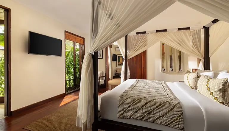 The Suar, Seminyak, Bali — bedroom with elegant four poster bed beautiful garden view | The Luxury Bali