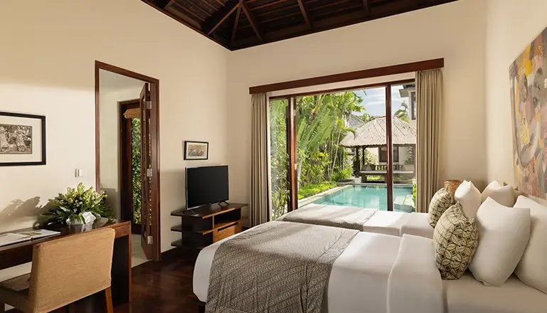 The Suar, Seminyak, Bali — bedroom with twin beds desk and stunning pool garden view | The Luxury Bali