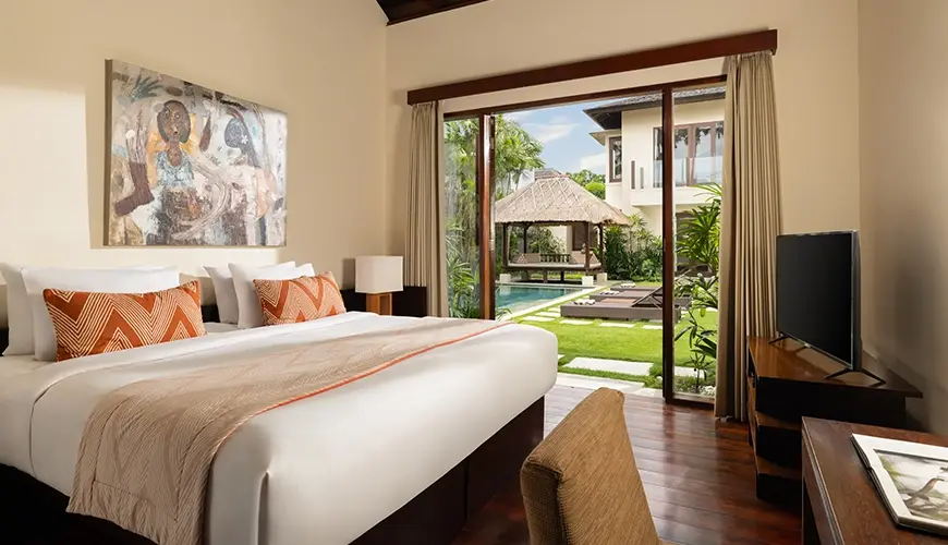 The Suar, Seminyak, Bali — spacious villa bedroom with a comfortable king bed and beautiful outdoor pool view | The Luxury Bali