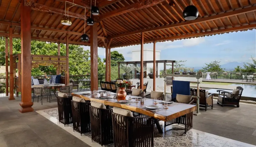 The Tulou Bali, Jimbaran, Bali — spacious outdoor dining area with a long table and seating | The Luxury Bali