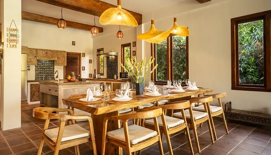 Tropical Svasti Villa, Canggu, Bali — rustic dining area with live edge table and woven lights | The Luxury Bali