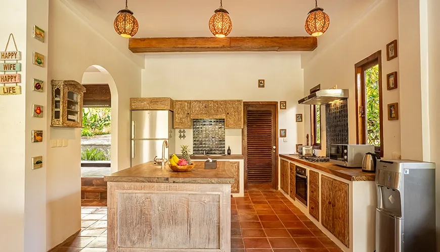 Tropical Svasti Villa, Canggu, Bali — rustic kitchen with wooden cabinets and traditional pendant lights | The Luxury Bali