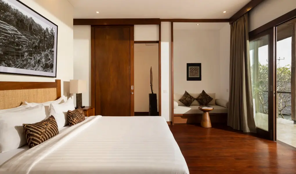 Villa Ambara, Canggu, Bali — cozy bedroom with dark wood floors and a private balcony | The Luxury Bali
