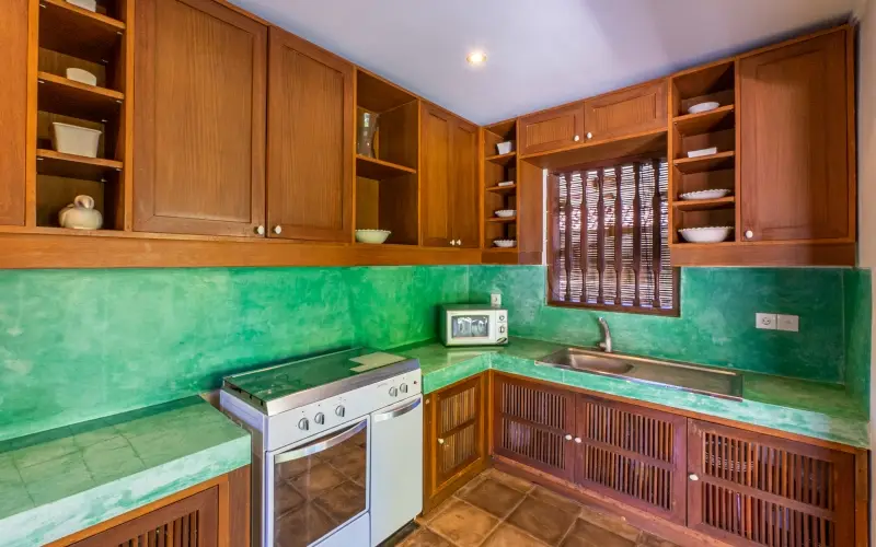 Villa Angsa, Sanur, Bali — kitchen with wooden cabinets bright green countertops and a stove | The Luxury Bali