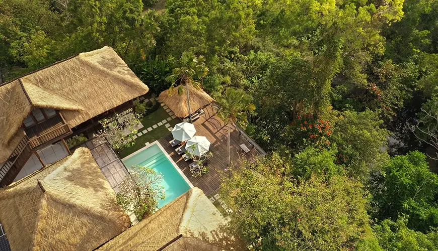 Villa Grasshopper, Jimbaran, Bali — stunning aerial drone view of a private thatched roof villa estate completely hidden within dense tropical | The Luxury Bali