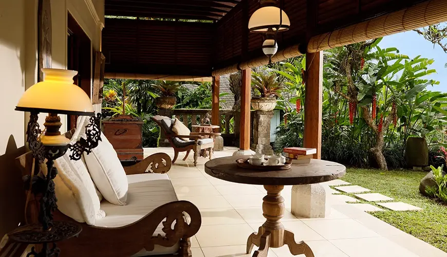 Villa Inka, Ubud, Bali — peaceful villa terrace with a wooden sofa ornate coffee table and comfortable seating surrounded by lush | The Luxury Bali