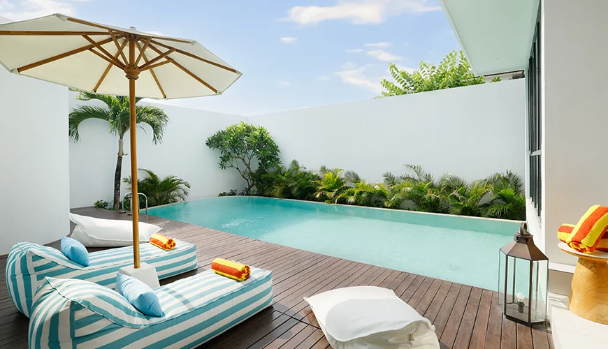Villa Kalem Canggu, Canggu, Bali — beautiful swimming pool with a wooden deck and bean bags | The Luxury Bali