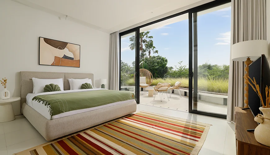 Villa Kalem Canggu, Canggu, Bali — elegant master bedroom with glass doors to a terrace | The Luxury Bali
