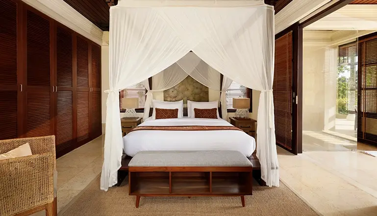 Villa Ken, Jimbaran, Bali — bedroom with canopy bed wooden wardrobes and bright outdoor view | The Luxury Bali