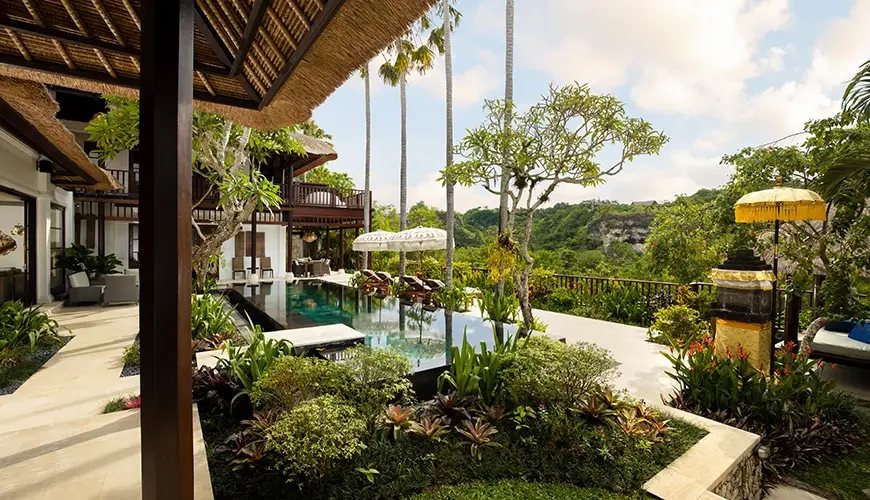 Villa Ken, Jimbaran, Bali — infinity pool with sun loungers overlooking lush green valley | The Luxury Bali