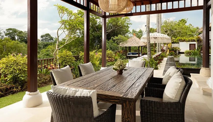 Villa Ken, Jimbaran, Bali — outdoor dining lounge with wooden table and lush garden views | The Luxury Bali