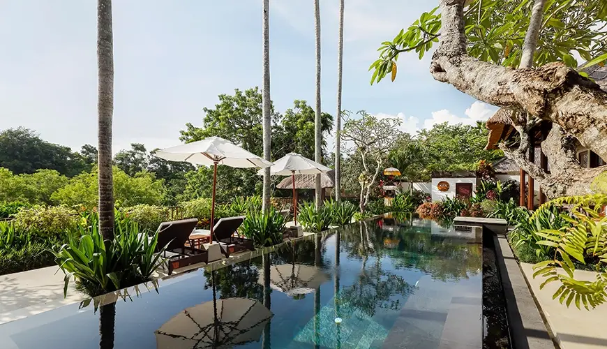 Villa Ken, Jimbaran, Bali — stunning private villa swimming pool with sun loungers surrounded by lush tropical gardens | The Luxury Bali
