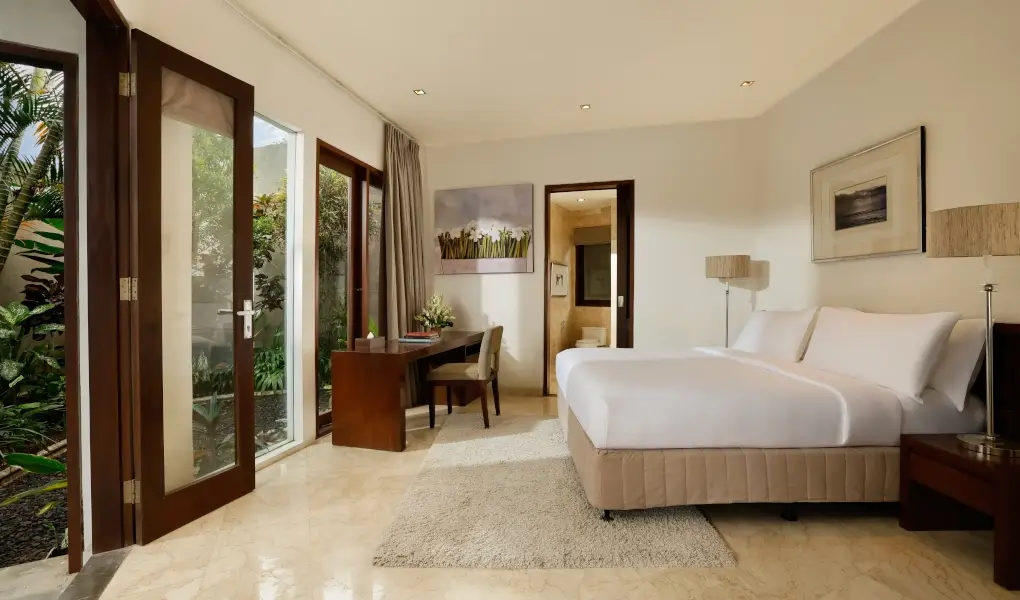 Villa Oshra, Canggu, Bali — bright bedroom with a bed and doors opening to a garden | The Luxury Bali