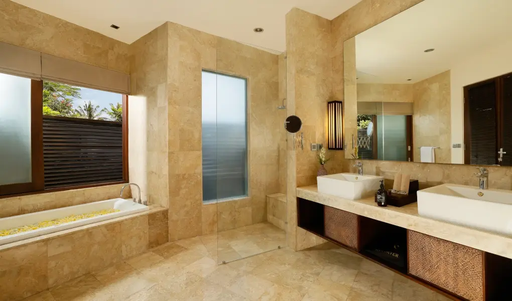 Villa Oshra, Canggu, Bali — marble tiled bathroom with dual sinks and a sunken bathtub | The Luxury Bali
