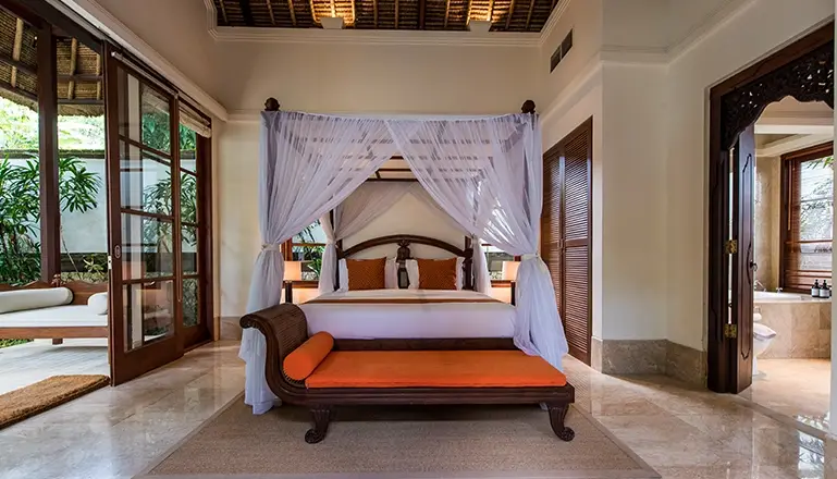 Villa Senada, Jimbaran, Bali — inviting bedroom with canopy bed connecting to bathroom and patio | The Luxury Bali