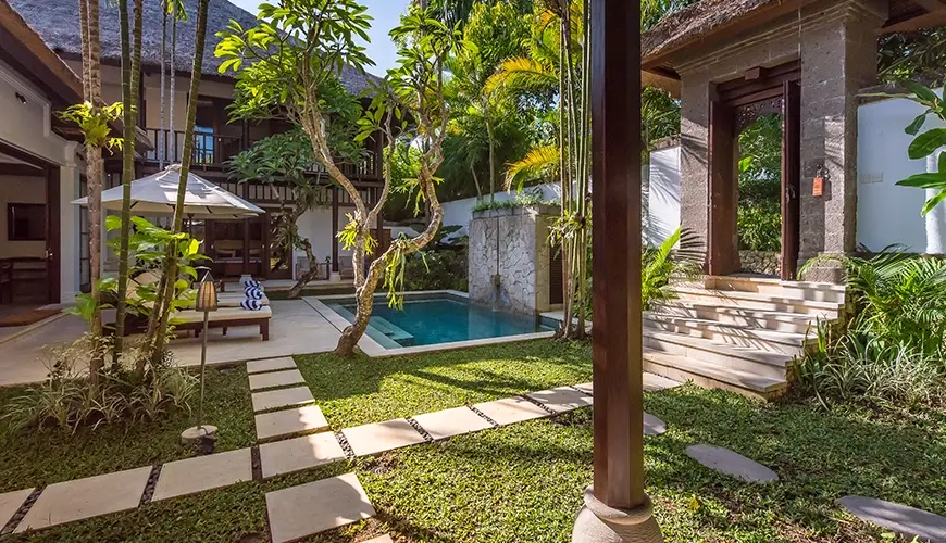 Villa Senada, Jimbaran, Bali — serene plunge pool surrounded by lush garden and traditional structures | The Luxury Bali