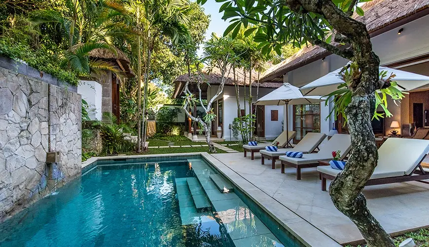 Villa Senada, Jimbaran, Bali — swimming pool with loungers and waterfall feature | The Luxury Bali