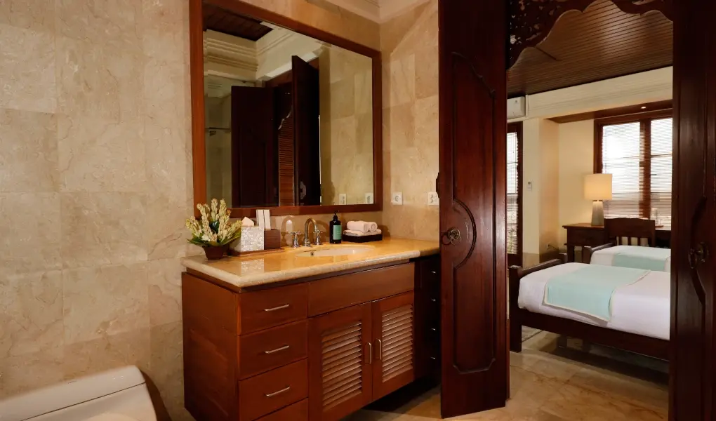 Villa The Seven, Jimbaran, Bali — ensuite bathroom with a vanity and a peek of a twin bedroom | The Luxury Bali