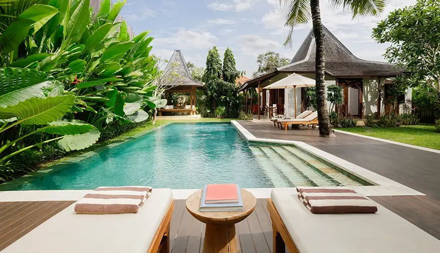 Tropical Svasti Villa, Canggu, Bali — beautiful outdoor pool area of a villa surrounded by lush tropical plants and traditional pavilion architecture | The Luxury Bali