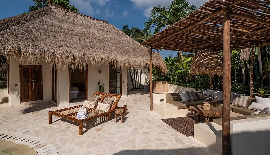 Villa Xanadu, Canggu, Bali — exterior of a tropical villa with a thatched roof bungalow and an attractive shaded lounge area | The Luxury Bali