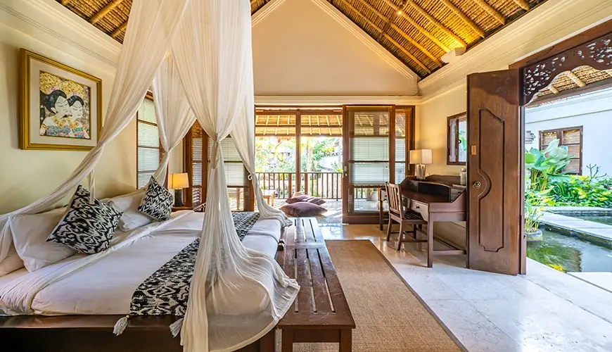 Villa Yasmine, Jimbaran, Bali — elegant bedroom with canopy bed traditional thatched roof and private balcony | The Luxury Bali